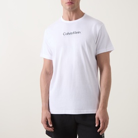 Model wearing Calvin Klein white cotton T-shirt with Blue Nights logo print at chest, relaxed fit loungewear style