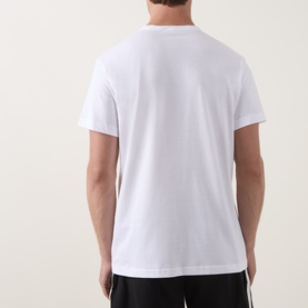 Model wearing Calvin Klein white cotton T-shirt, back view, styled with black trousers