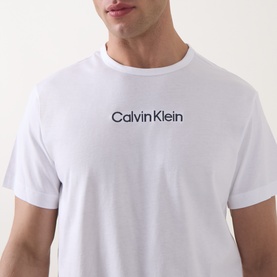Model wearing Calvin Klein white cotton T-shirt with Blue Nights logo print at chest, crew neckline and short sleeves.