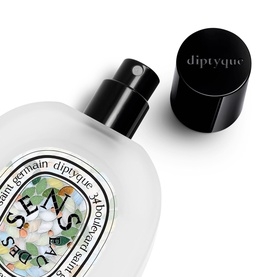 Diptyque Sens Eau de Toilette spray bottle with black cap removed, floral label detail visible on frosted glass flacon