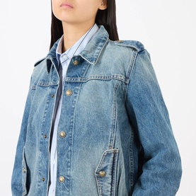 Model wearing Nili Lotan denim jacket in Rosebowl Wash, gold-tone snap buttons, chest pockets, styled over a stripe shirt.