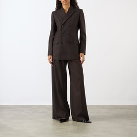 Model wearing Nili Lotan brown herringbone double-breasted blazer jacket, styled with matching wide-leg trousers and black shoes.