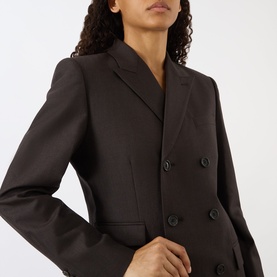 Model wearing Nili Lotan brown herringbone double-breasted blazer jacket with notched lapels and black buttons, close-up view.