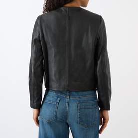 Model wearing Nili Lotan Ophelie Cropped Leather Jacket in black, collarless with long sleeves, styled with blue jeans. Back view.