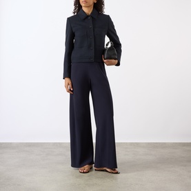 Model wearing Nili Lotan midnight navy jacket with matching wide-leg trousers, styled with black bag and flat sandals.