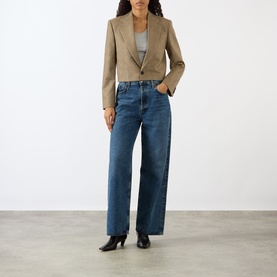 Model wearing Nili Lotan Glen Tan cropped blazer jacket, styled with wide-leg blue jeans and black heeled mules.