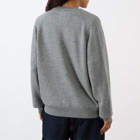 Model wearing Nili Lotan pebble grey heather knit sweater, back view, styled with dark denim jeans.