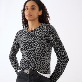 Model wearing Nili Lotan knitwear in Pebble Grey Heather and Black Cheetah print, styled with black jeans and belt