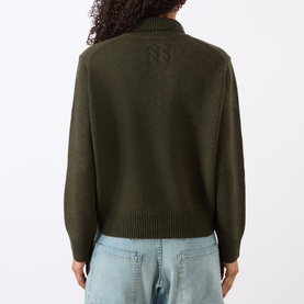 Model wearing Nili Lotan Renata Turtleneck Sweater in Dark Pine Melange, back view, styled with light blue jeans