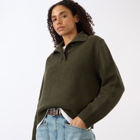 Model wearing Nili Lotan Renata Turtleneck Sweater in Dark Pine Melange lambswool, half placket neck, styled with light wash jeans and belt.