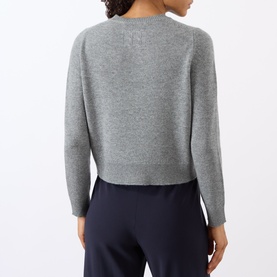 Model wearing Nili Lotan pebble grey heather knit sweater, back view, styled with navy wide-leg trousers.