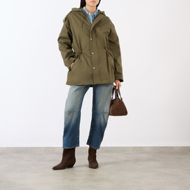 Model wearing Nili Lotan Lucienne Parka Jacket in Army Green with snap placket and drawstring waist, styled with blue jeans and brown ankle boots.