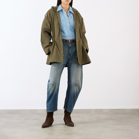 Model wearing Nili Lotan Lucienne Parka Jacket in Army Green with blue denim shirt, straight-leg jeans and brown ankle boots.