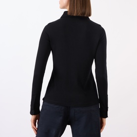 Model wearing Nili Lotan black 100% wool turtleneck long-sleeve shirt, rear view, styled with navy trousers.