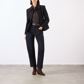 Model wearing Nili Lotan chocolate brown silk shirt with navy blazer, matching trousers, brown belt and ankle boots.