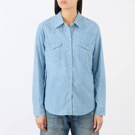 Model wearing Nili Lotan Indigo Chambray cotton shirt with Western-style snap buttons and twin chest pockets, styled with blue jeans.