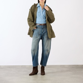 Model wearing Nili Lotan Indigo Chambray shirt, styled with olive utility jacket, blue jeans and brown ankle boots.