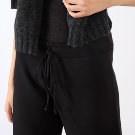 Model wearing Nili Lotan Kiki Drawstring Flared Sweatpants in Washed Black, showing elasticated drawstring waistband, styled with dark knit top.