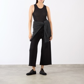 Model wearing Nili Lotan Kiki Drawstring Flared Sweatpants in Washed Black with black tank top and dark jacket tied at waist.