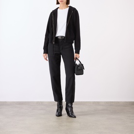 Model wearing Nili Lotan carbon cotton trousers, styled with black zip hoodie, white tee, black ankle boots and small black handbag.