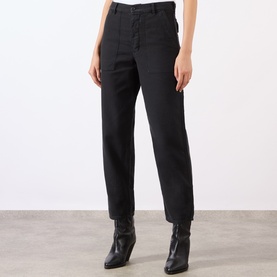 Model wearing Nili Lotan carbon black cotton trousers with front pockets, styled with black ankle boots.