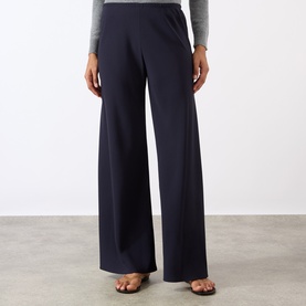 Model wearing Nili Lotan midnight wide-leg trousers with a grey top and strappy sandals.