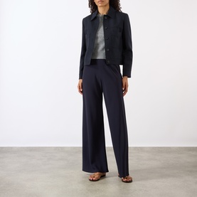 Model wearing Nili Lotan midnight wide-leg trousers, styled with matching cropped jacket, grey top and brown sandals.