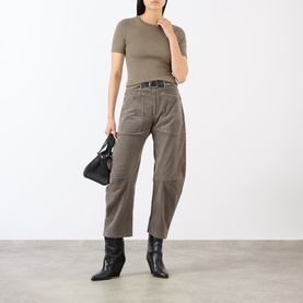 Model wearing Nili Lotan Shon Cargo Trousers in Sage Grey with a khaki T-shirt, black ankle boots, and carrying a black handbag.