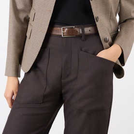 Model wearing Nili Lotan Brown Herringbone wool trousers with pleated front and side pockets, styled with a beige houndstooth blazer and brown belt.