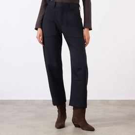 Model wearing Nili Lotan midnight wool trousers with straight leg fit, styled with brown ankle boots and grey long-sleeve top.