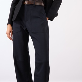Model wearing Nili Lotan midnight wool trousers with patch pockets, styled with a black blazer and brown leather belt.