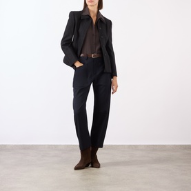 Model wearing Nili Lotan midnight wool trousers, styled with a dark blazer, brown shirt, belt, and brown ankle boots.