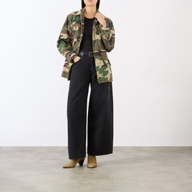 Model wearing green camouflage military jacket with black wide-leg trousers, black belt, and khaki ankle boots