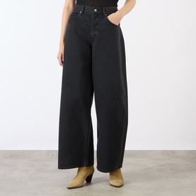Model wearing black wide-leg high-rise jeans with five-pocket styling, paired with tan heeled mules