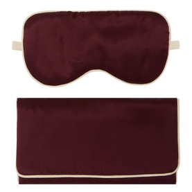Olivia von Halle silk eye mask and pouch set in raisin burgundy with cream trim edging, laid flat on white background.