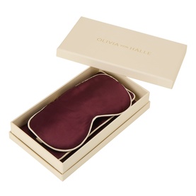 Olivia von Halle Raisin silk eye mask in cream gift box with logo lid, presented open to show burgundy mask inside.