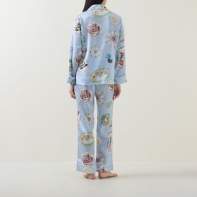 Model wearing Olivia von Halle Lila Cadiz Seafood Pyjamas in blue silk with allover seafood print, shown from behind in full-length set