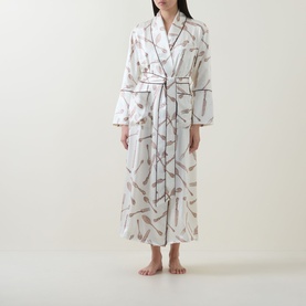 Model wearing Olivia von Halle Capability Sevilla Silverware Robe in cream silk with silverware print, shawl collar, contrast piping and self-tie belt