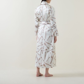 Model wearing Olivia von Halle Capability Sevilla Silverware Robe in cream silk with silverware print, contrast piping, and self-tie belt, back view