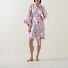 Model wearing Olivia von Halle Mimi Selene Swan Robe in pink silk with swan print, shawl collar, three-quarter sleeves and self-tie belt