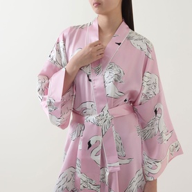 Model wearing Olivia von Halle Mimi Selene Swan Robe in pink silk with swan print, shawl collar, three-quarter sleeves and self-tie belt