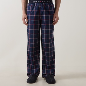 Model wearing Tommy Hilfiger Pyjama Bottom in navy Rwb Windowpane Check, relaxed fit, 100% cotton, styled with dark slippers.