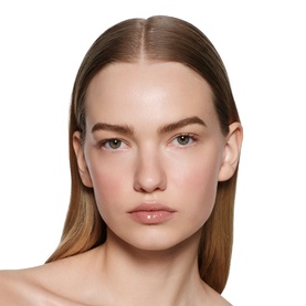 Model wearing Victoria Beckham Posh Gloss in Bikini, a sheer nude lip gloss, with a fresh, natural makeup look.