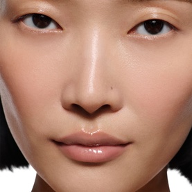 Model wearing Victoria Beckham Posh Gloss in Bikini, a sheer glossy lip finish with a natural, luminous look.