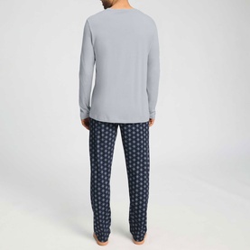 Model wearing Hanro Pyjamas Set in Celestial Night, grey long-sleeve top with navy geometric print trousers, rear view