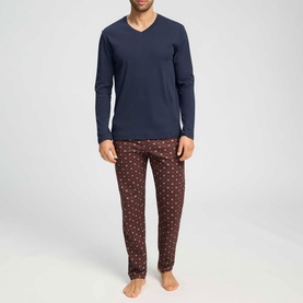 Model wearing Hanro Pyjamas Set in Sagittarius, navy long-sleeve V-neck top with dark red geometric-print trousers