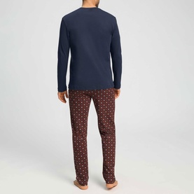 Model wearing Hanro Pyjamas Set in Sagittarius, navy long-sleeve top with burgundy geometric print trousers, rear view.