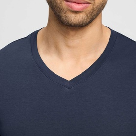 Model wearing Hanro Pyjamas Set in Sagittarius navy, close-up of v-neck top neckline detail in smooth jersey fabric.