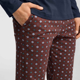 Model wearing Hanro Pyjamas Set in Sagittarius, showing burgundy trousers with teal and white geometric floral print and side pocket.