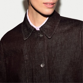 Model wearing Jigsaw burgundy denim jacket, close-up of collar and button placket detail, styled with a lilac top underneath.